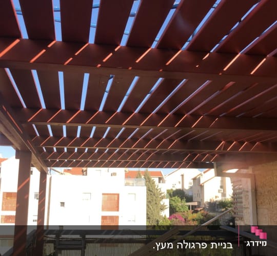 פרגולה מעץ עם קורות אופקיות בגינה